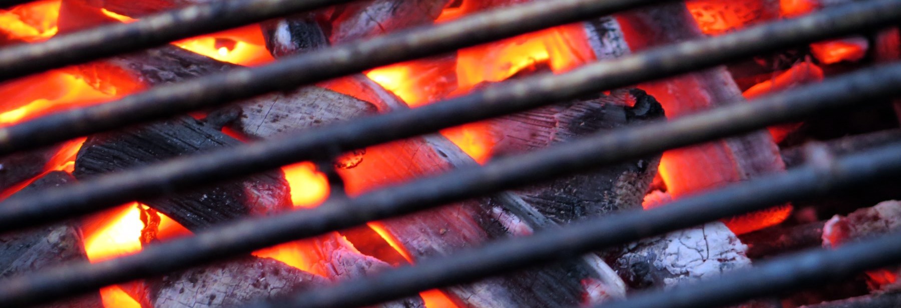 Barbeque grill showing coals and fire below